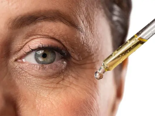 Goccia di siero al retinolo vicino all'occhio per combattere le rughe. Scopri come usarlo per una pelle più giovane.