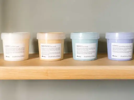 Quattro maschere per capelli Davines su uno scaffale. Scopri quanto tenerla per un trattamento ottimale.