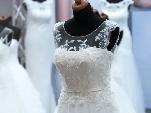 Abiti da sposa bianchi e ricamati su manichini, pronti per la donna che sogna il suo giorno speciale.
