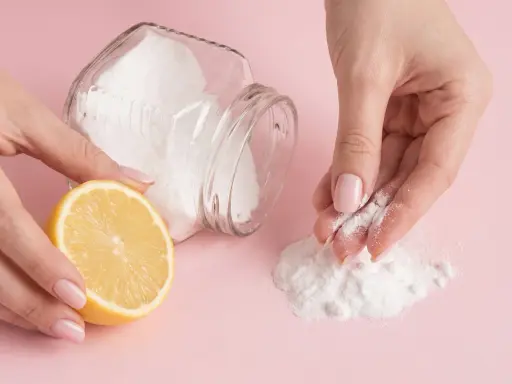 Mani che preparano una maschera fai-da-te con limone e bicarbonato per scoprire come togliere i brufoli dal viso.