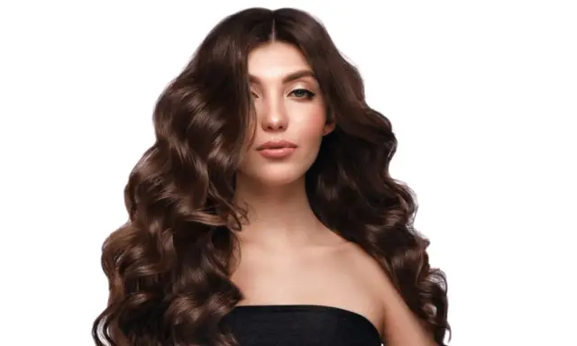 Capelli castani, lunghi e ondulati, morbidi e lucenti grazie al segreto di lasciare il balsamo sui capelli tutta la notte.