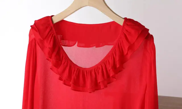 Blusa in chiffon rossa con ruches sul collo e sulle maniche. Un capo elegante e leggero.