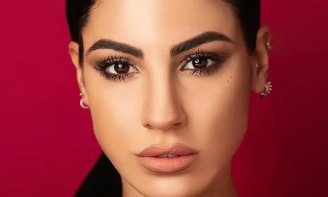 Volto di donna con trucco cerimonia semplice ed elegante: occhi scuri e labbra nude.