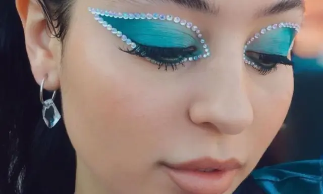 Occhi con ombretto blu elettrico e strass scintillanti, un look che fa make up euphoria. Orecchino pendente con cristallo.