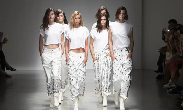 Sfilata Alberta Ferretti: abiti bianchi con dettagli scintillanti, un'espressione di filosofia minimalista e audace.