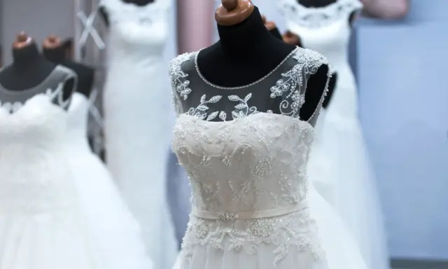Abiti da sposa bianchi e ricamati su manichini, pronti per la donna che sogna il suo giorno speciale.