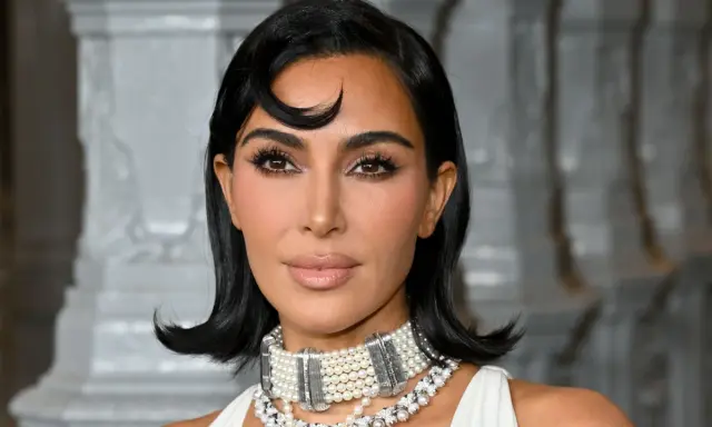 Kim Kardashian con un look sofisticato, evidenziando la tecnica del "baking" per un incarnato impeccabile.