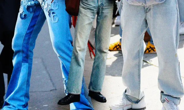 Gambe in primo piano con diversi modelli di moschino jeans: uno blu con inserti e ricami, uno più chiaro e sbiadito, e uno grigio chiaro oversize.