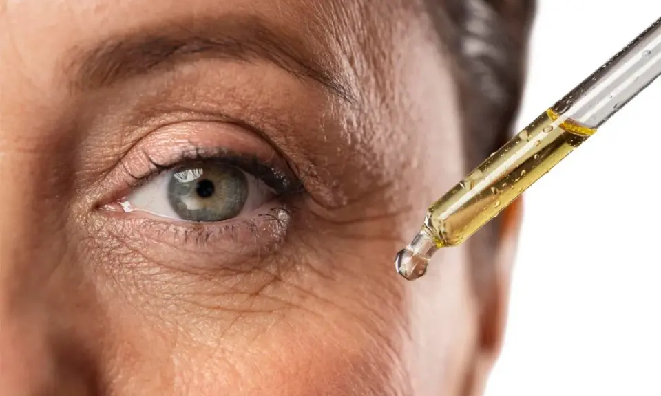 Goccia di siero al retinolo vicino all'occhio per combattere le rughe. Scopri come usarlo per una pelle più giovane.