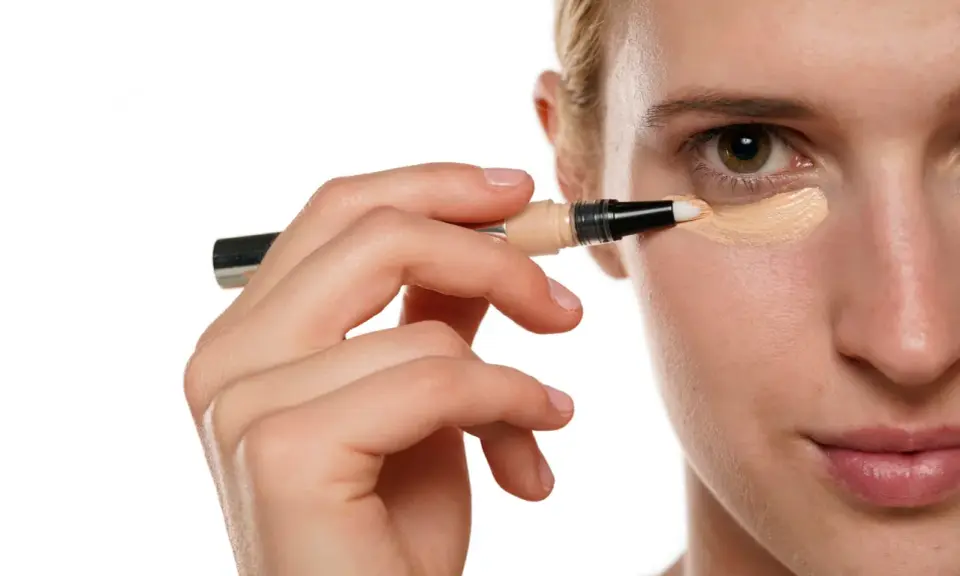 Applicazione di correttore sotto l'occhio, un passo essenziale per chi vuole sapere come togliere trucco waterproof e avere un incarnato perfetto.