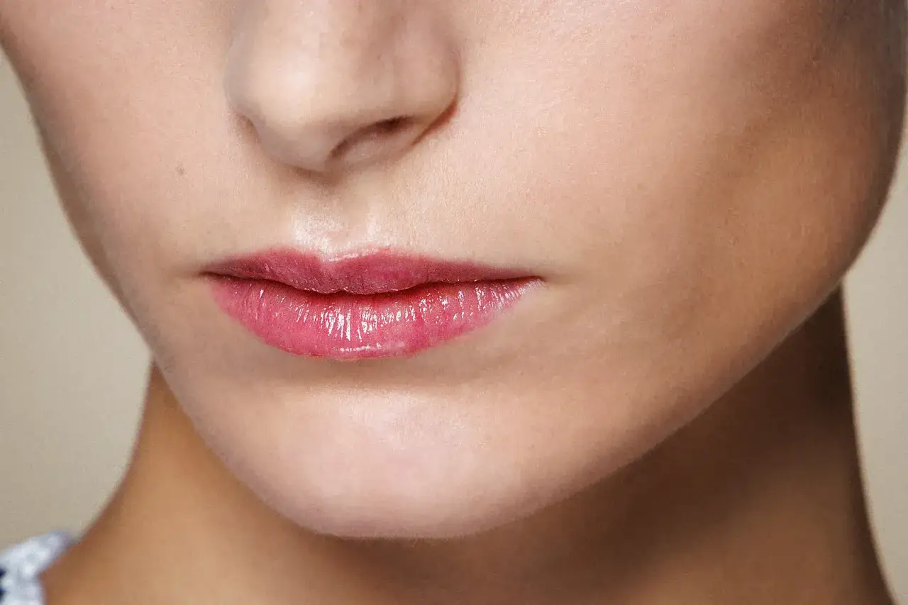 Labbra piene e luminose con un tocco di gloss rosato, un esempio di trucco labbra sottili che dona volume e sensualit&agrave;.
