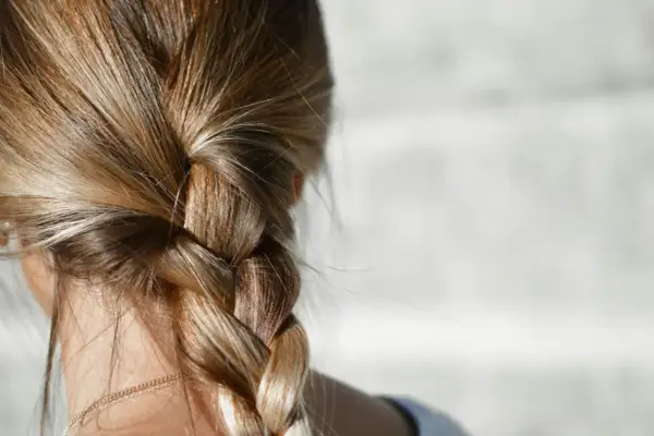 Capelli biondi intrecciati in una treccia. Per chi ha capelli grassi, la frequenza di lavaggio è una questione personale.